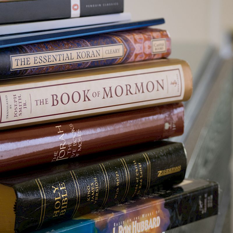 A stack of religious and spiritual books, including 