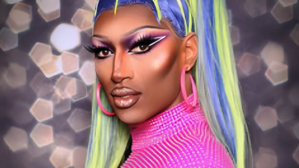 Person in vibrant makeup and outfit with neon green and pink colors, against a sparkling bokeh background.